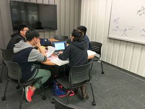 Image of students studying in a library group study room